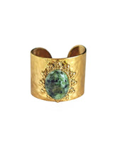Goldener Ring mit grün gesprenkeltem Stein und Sonnenmotiv in Schalenform